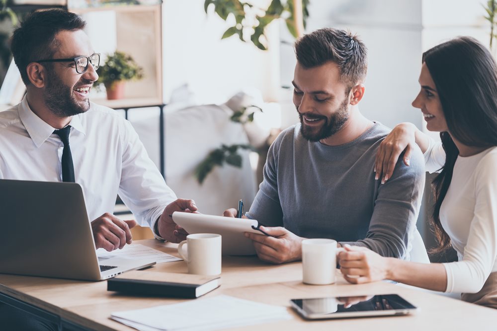 man and woman signing account forms together