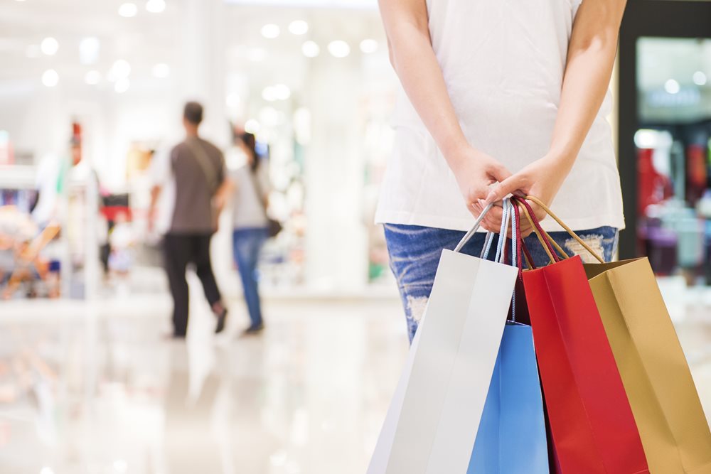 Woman holding shopping bags in a mall while shopping for Black Friday deals