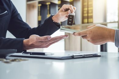 person handing over cash for car keys