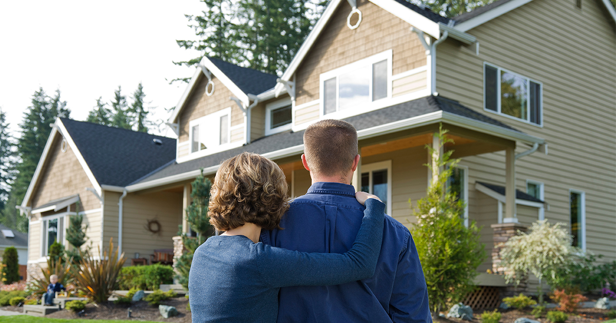 couple looking at house in front of them