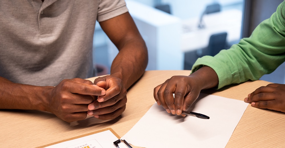 two people preparing to sign a loan agreement