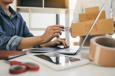 person sitting at desk with laptop and business supplies