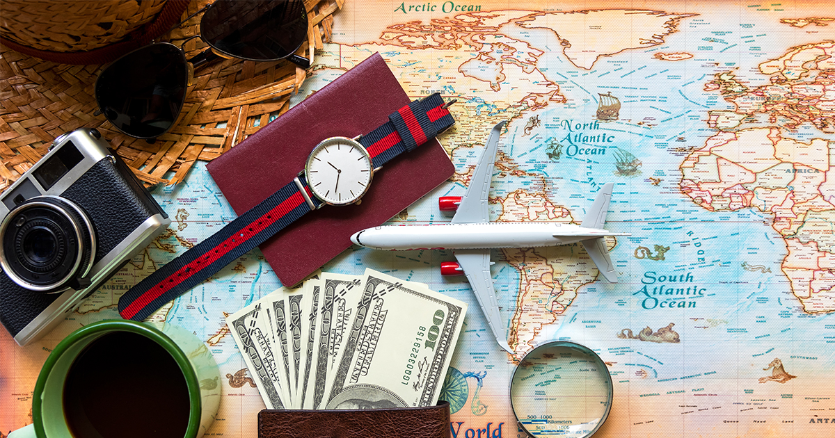 flatlay of travel items and world map